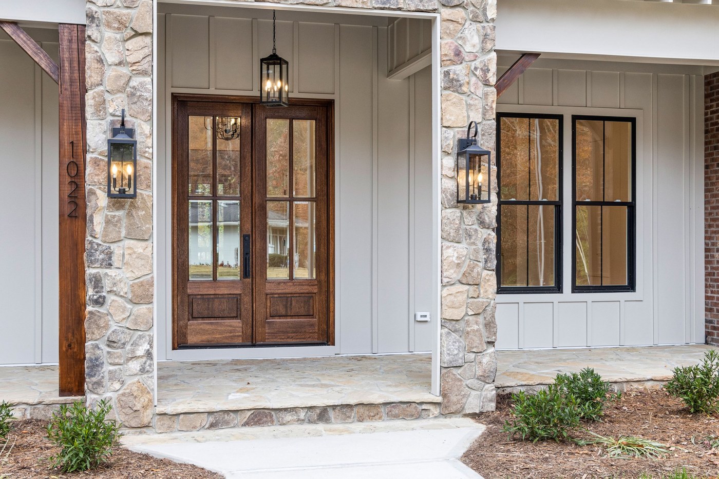 A paneled entry door with brass hardware and a stone surround, photographed close