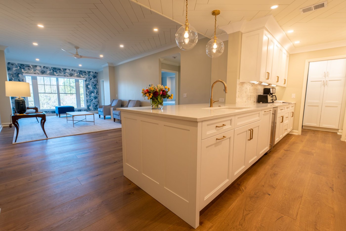A kitchen island and stools in a bright room, the morning light across the counter